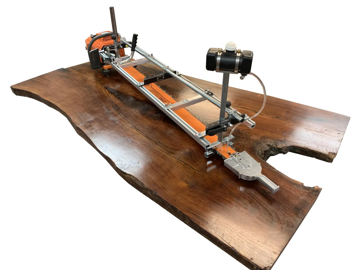 Alaskan MKIV mill on a double-end bar with a helper handle and auxiliary oiler, resting on a walnut slab