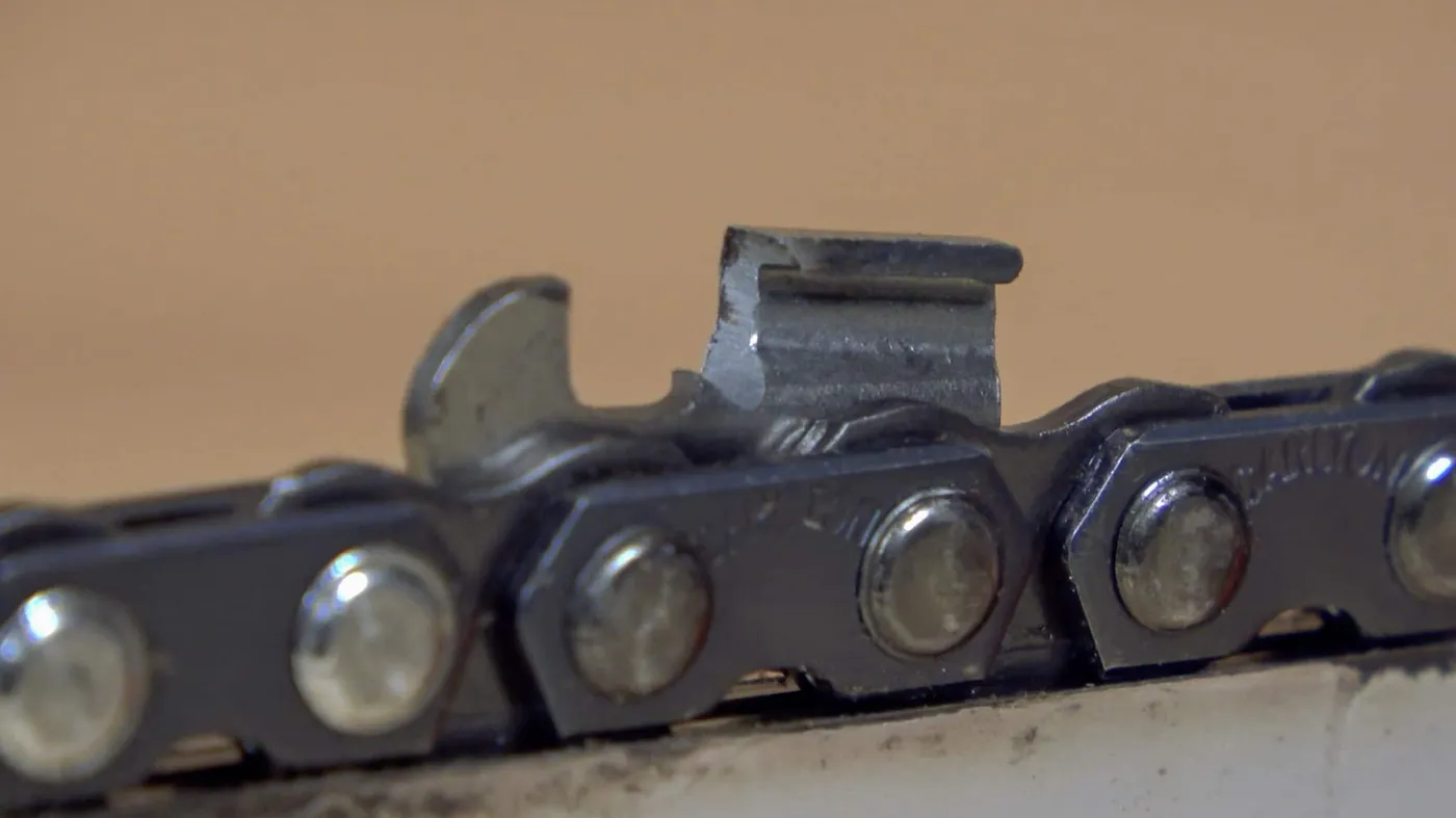 Close-up of a ripping chain cutter and drive links on a chainsaw bar