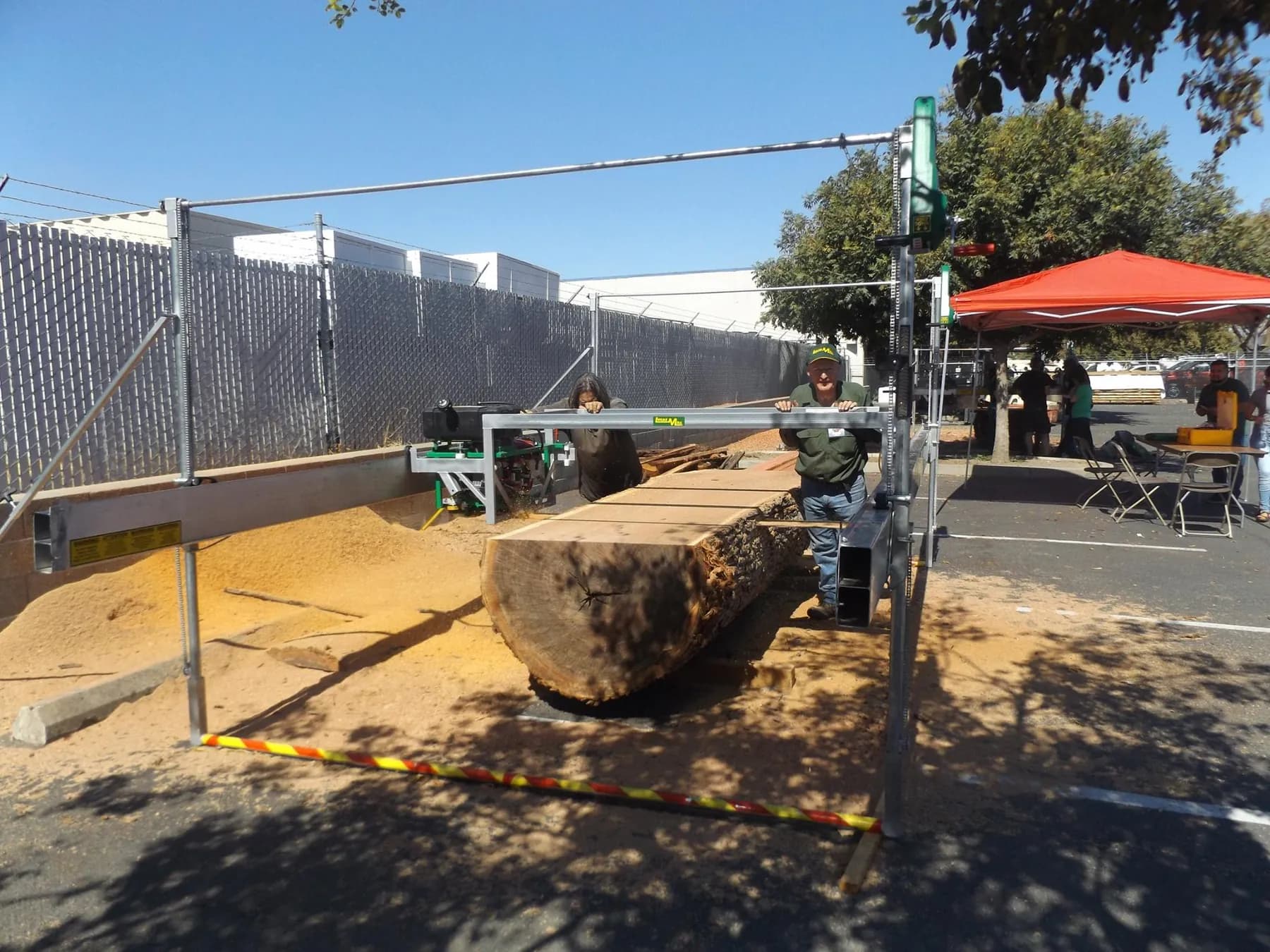 Lucas Mill over a sawn log and a pile of sawdust at a Bailey’s demo day