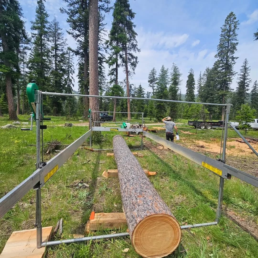 Lucas Mill tracks and end-frames set up over a pine log in a meadow