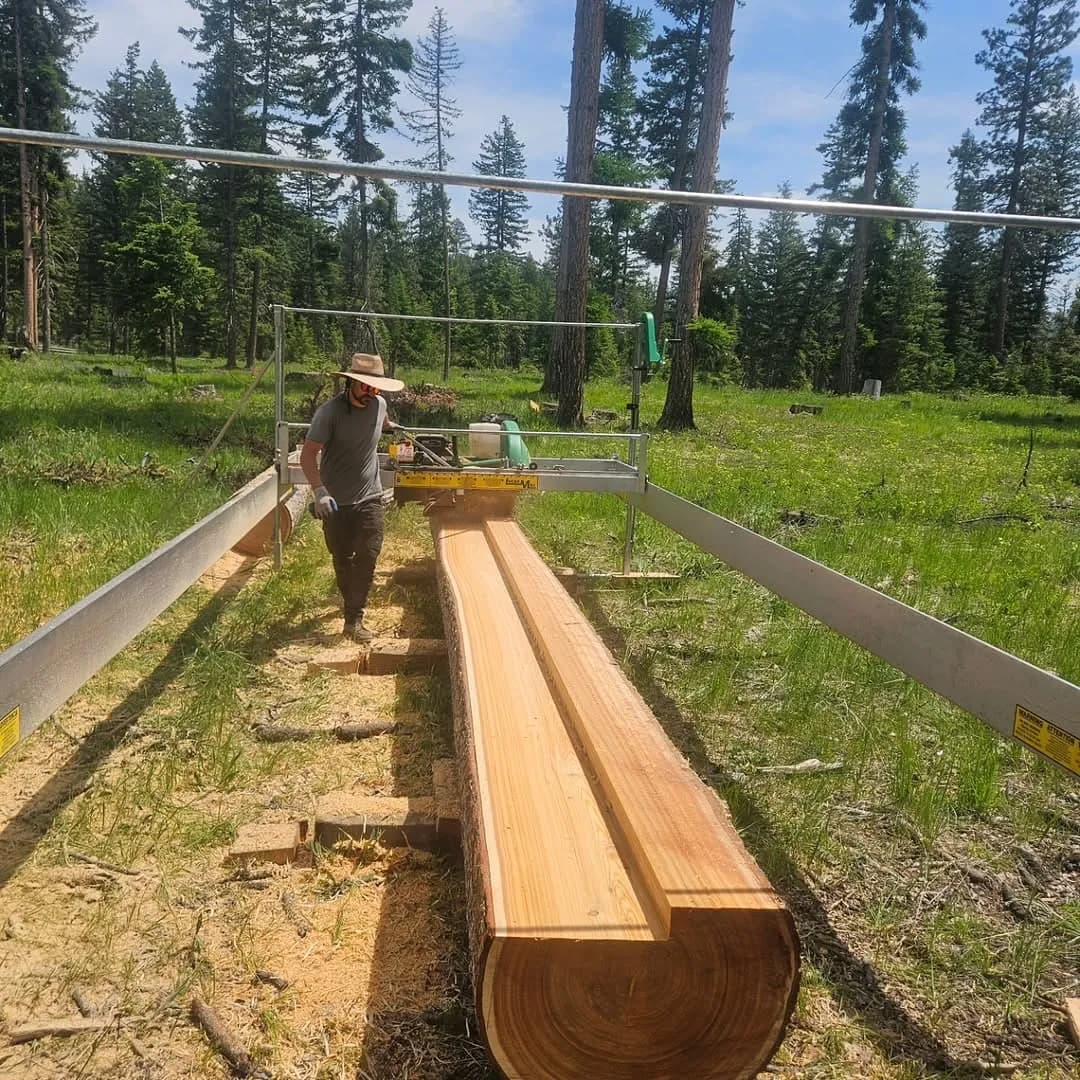 Operator milling a long beam on a Lucas Mill in a meadow