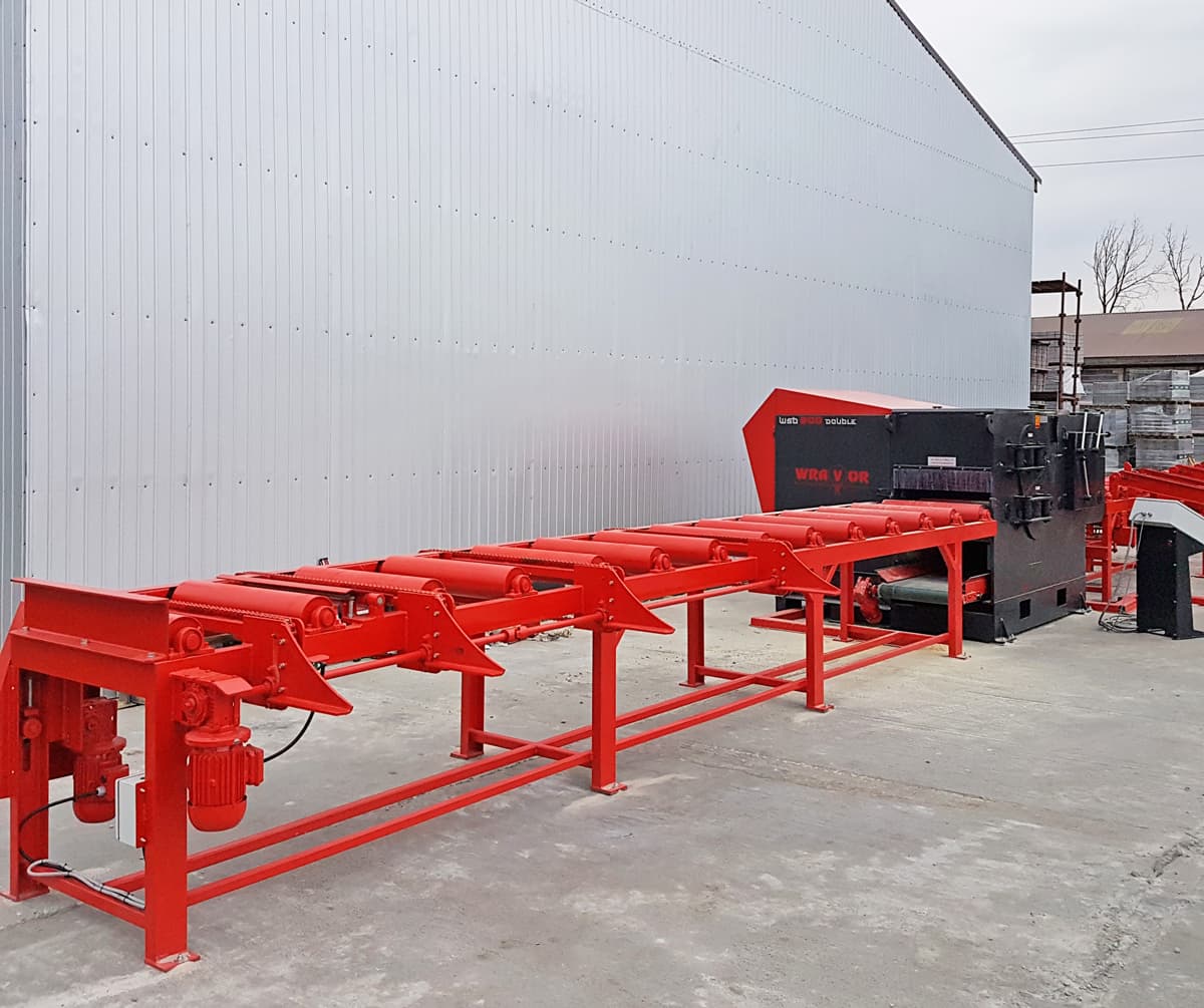 Wravor CS line: long red conveyor leading to a multi-rip saw beside an industrial building